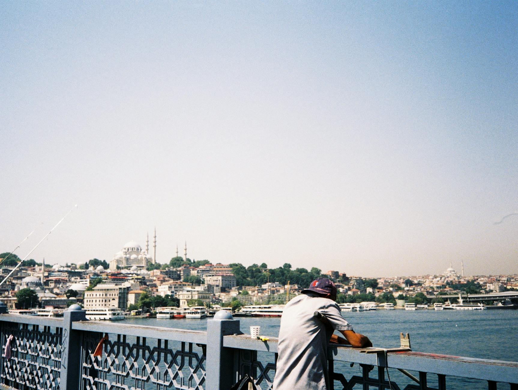 Mężczyzna na moście podziwia panoramę Stambułu i Bosfor