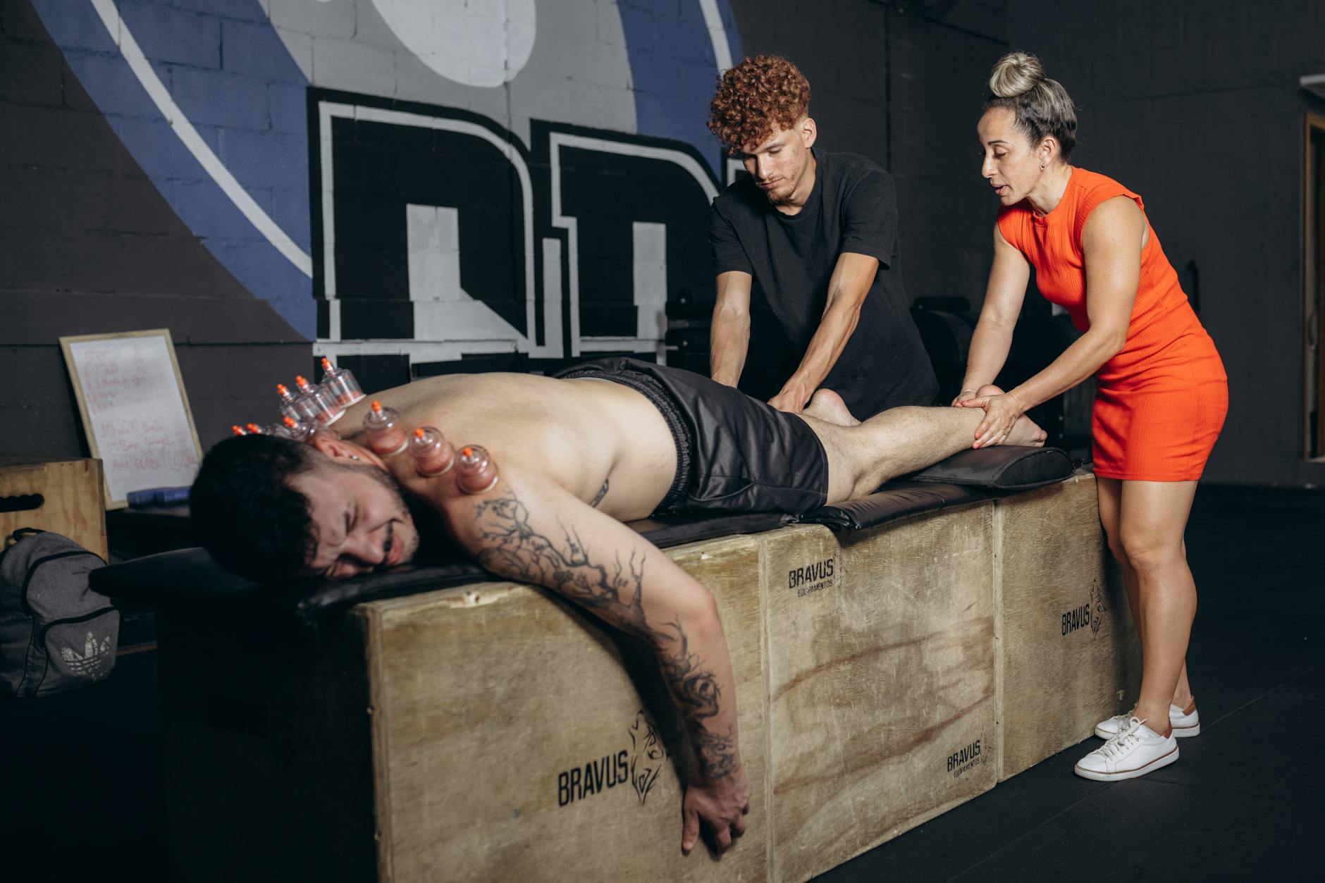 Zawodnik w siłowni podczas terapii bańkami i masażu regeneracyjnego