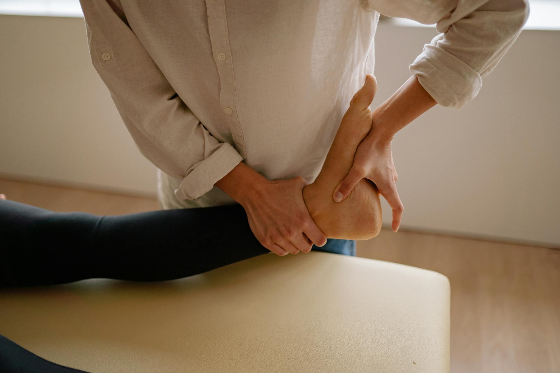 Terapeuta wykonuje drenaż limfatyczny stopy po skręceniu kostki