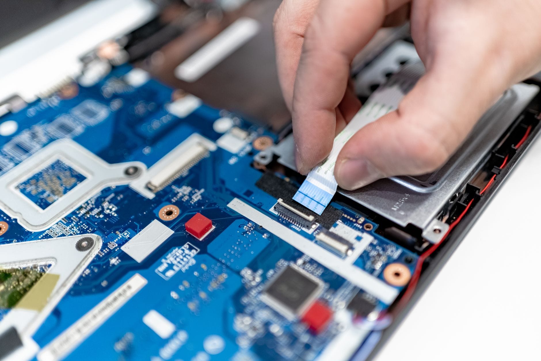 Serwis laptopów Toshiba w Katowicach: kompleksowy przewodnik po naprawie matryc, klawiatur i zasilania Serwisant naprawia płytę główną laptopa Toshiba z użyciem narzędzi