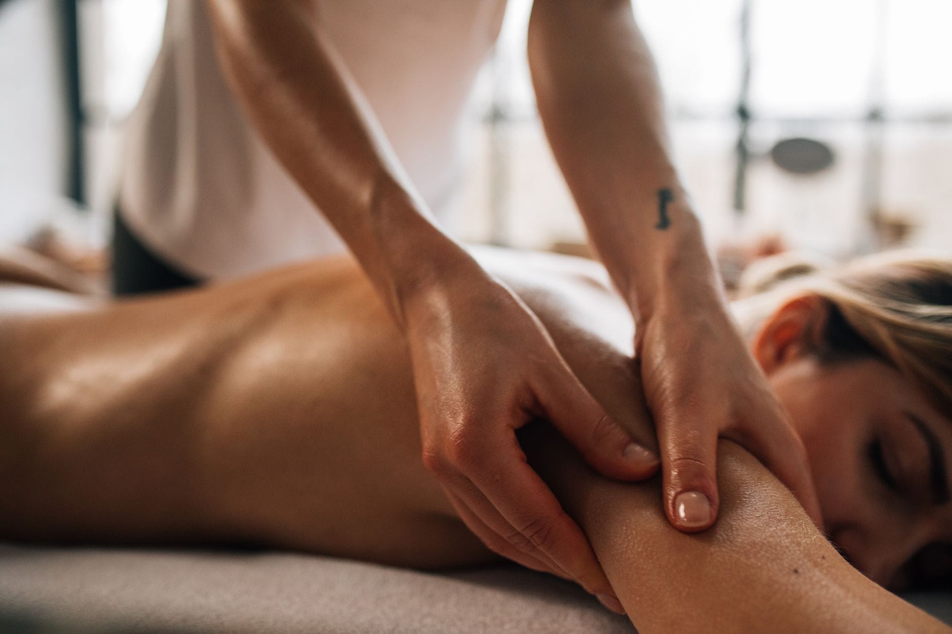 Masażystka wykonuje relaksacyjny masaż pleców w gabinecie spa