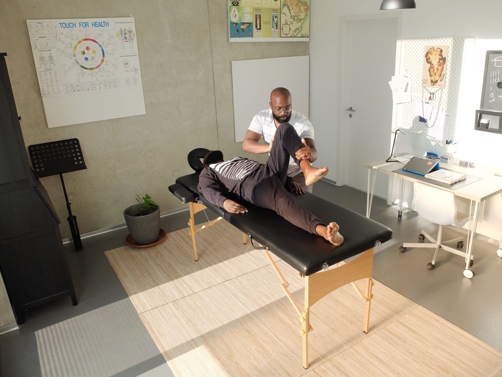 Terapeuta wykonuje masaż sportowy mięśnia w gabinecie klinicznym