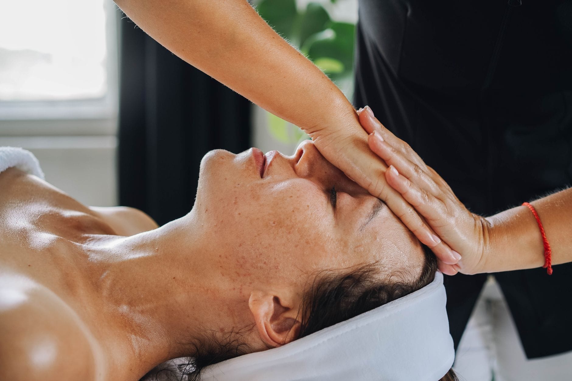 Kobieta podczas relaksującego masażu kobido w spokojnym spa Kobieta podczas relaksującego masażu kobido w spokojnym spa