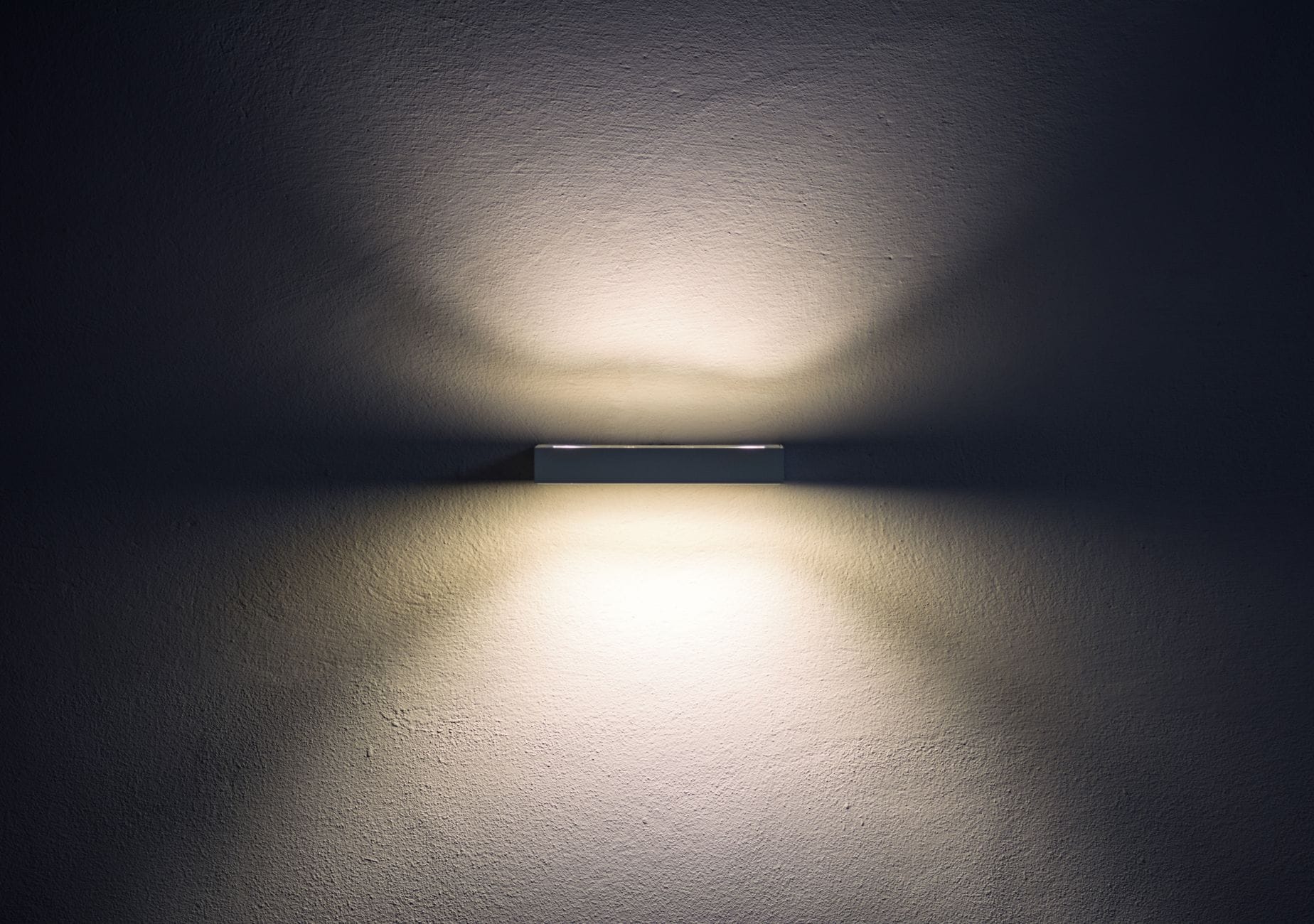 Minimalistyczna kinkietowa lampa LED rzucająca miękkie cienie na ścianę Minimalistyczna kinkietowa lampa LED rzucająca miękkie cienie na ścianę
