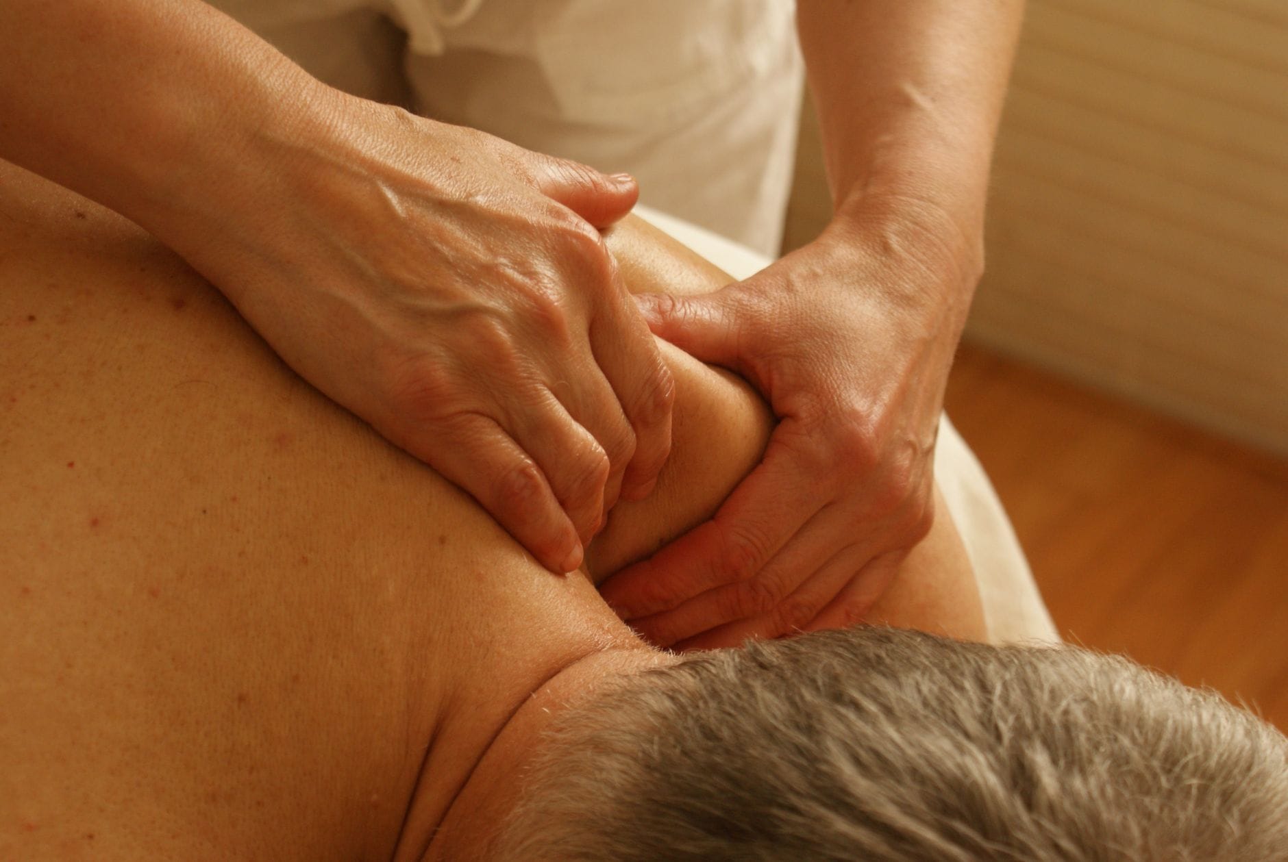 Terapeuta wykonuje relaksacyjny masaż barku dla redukcji stresu